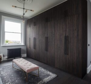 “Luxury walk-in wardrobe with custom shelving and lighting by Topmart Bespoke”